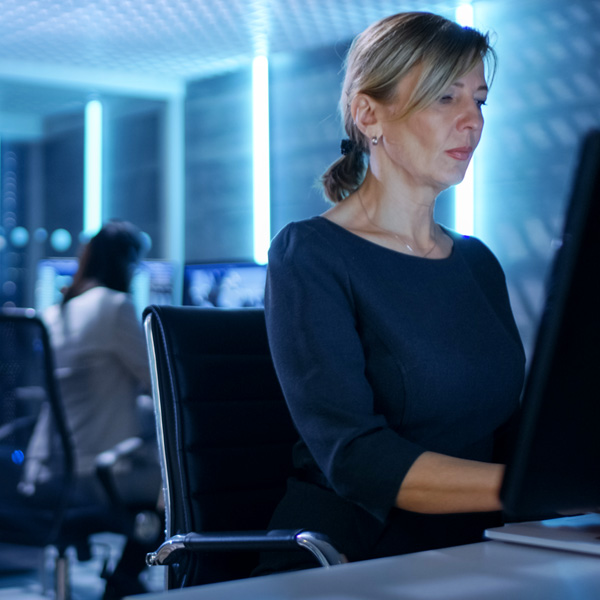 Woman on computer near server room