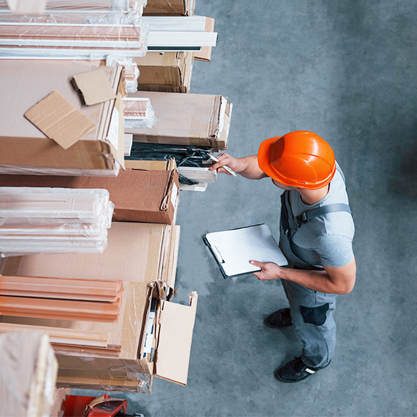 Warehouse worker with clipboard taking inventory aerial view