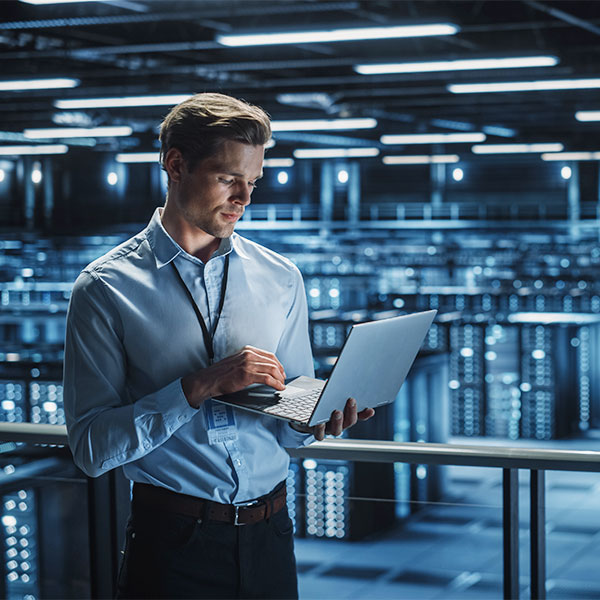 Man with laptop in large data center