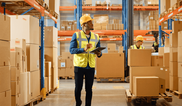 Man with tablet assessing warehouse stock