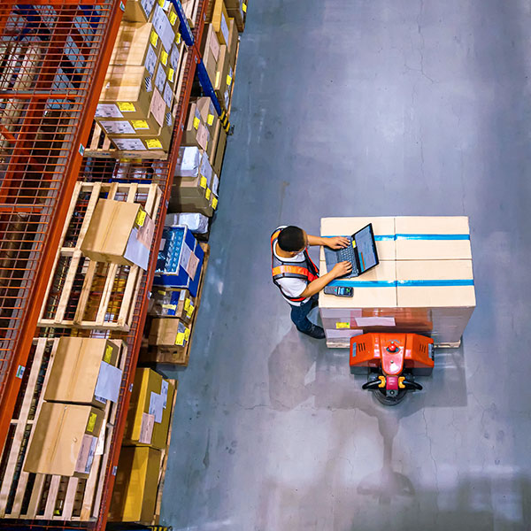 Warehouse worker using laptop aerial